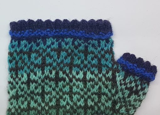 détail de mitaine en tricot jacquard bleu turquoise et violet
