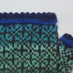 détail de mitaine en tricot jacquard bleu turquoise et violet