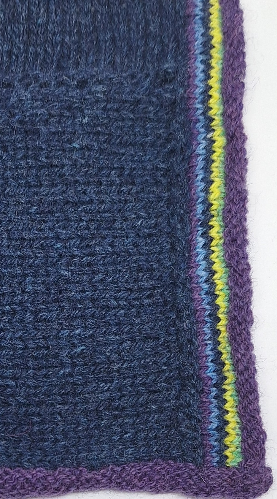 Détail de la veste bleue indigo Erika avec rayures multicolores. A tricoter en jacquard.