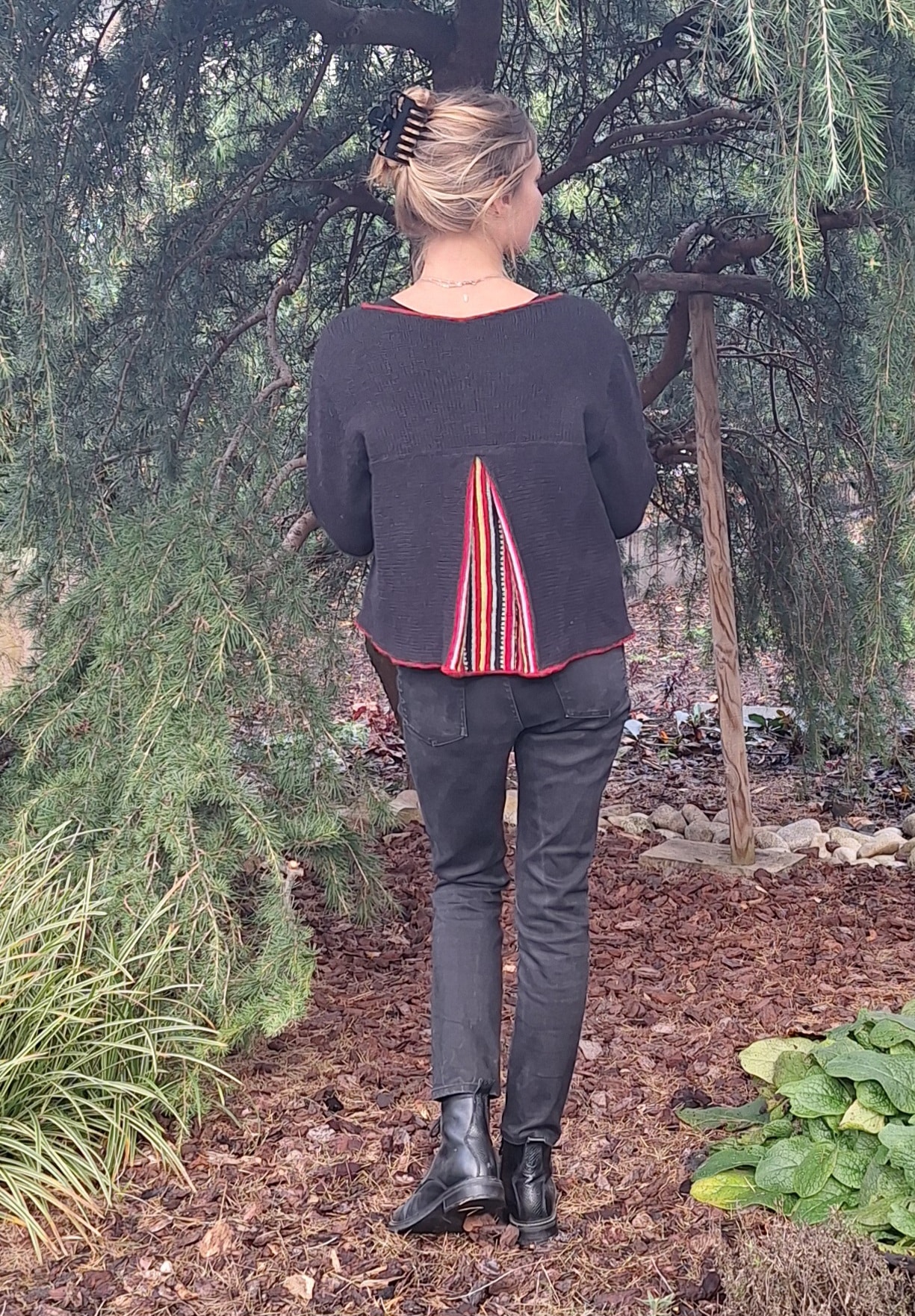 Veste noire avec pli creux rayé coloré au dos.