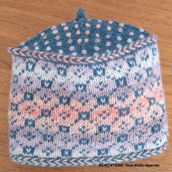 Toque en jacquard et doublée. Tons bleus et roses.